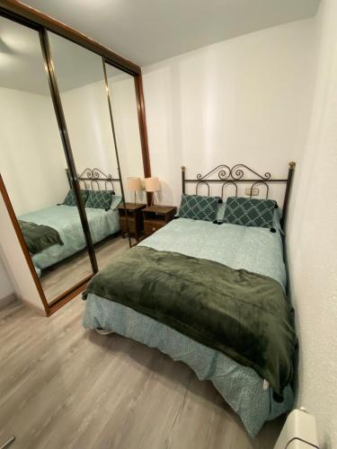 1 dormitorio con cama y espejo grande en Precioso y confortable piso en el Casco Histórico, en Oviedo