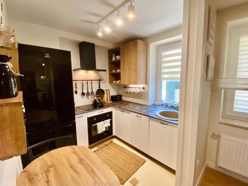 a kitchen with a black refrigerator and a sink at Apartamenty na Klasztornej in Jasło