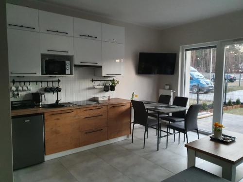 a kitchen and dining room with a table and chairs at Słoneczny Zakątek in Pogorzelica