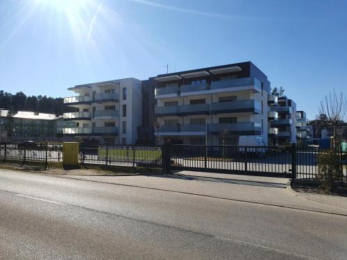 a building with a fence in front of a street at Słoneczny Zakątek in Pogorzelica