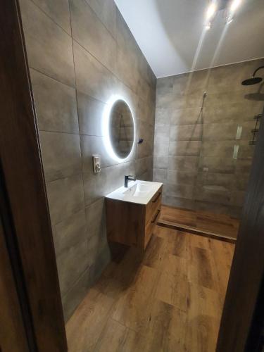 a bathroom with a sink and a mirror at Słoneczny Zakątek in Pogorzelica