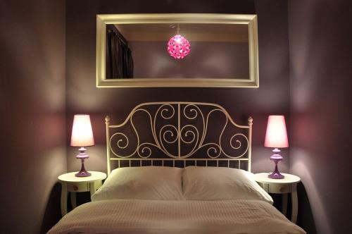 um quarto com uma cama com 2 candeeiros e um espelho em Chmielna Guest House em Varósvia