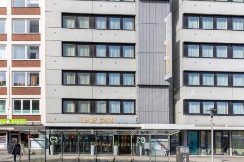 a tall white building with a ttip rum store at Trip Inn Hotel Münster City in Münster