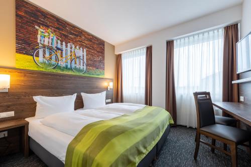 Cette chambre comprend un lit et un bureau. dans l'établissement Trip Inn Hotel Münster City, à Münster