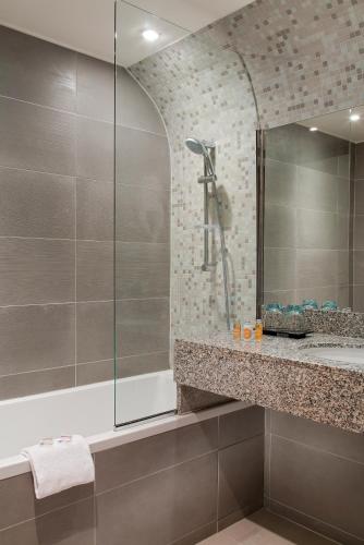 a bathroom with a shower and a sink at Timhotel Opéra Blanche Fontaine in Paris