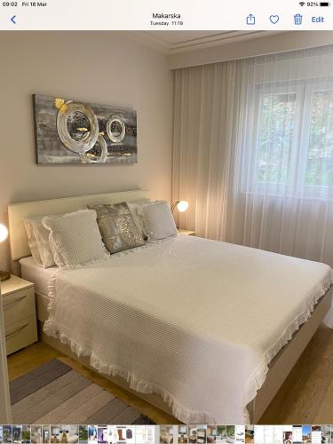 a bedroom with a bed with white sheets and a window at Sole in Makarska