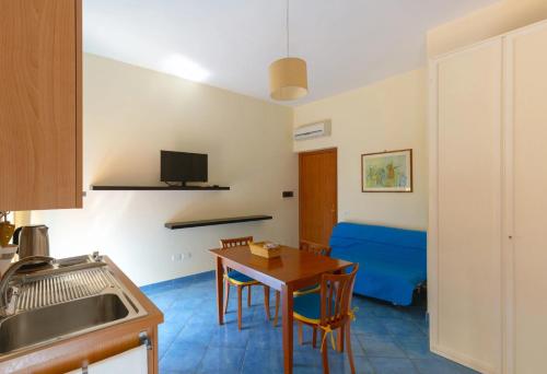a kitchen and dining room with a table and a blue couch at Villa Rosa Sorrento in Sorrento