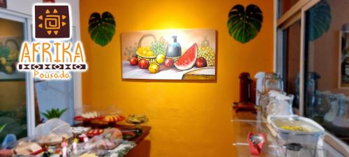a yellow wall with a painting of fruit on it at Pousada Afrika in Porto De Galinhas