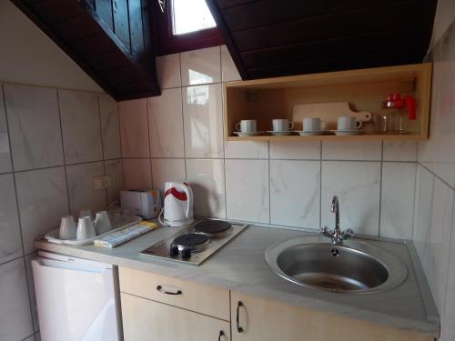 a kitchen with a sink and a counter top at Napsugár Apartman in Baja