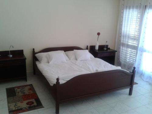 a bed with white sheets and pillows in a bedroom at Napsugár Apartman in Baja