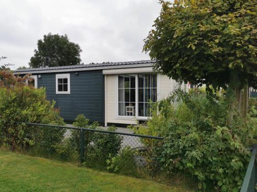 a gray house with a window and a fence at Chalet - Dà gae nog à in Baarland