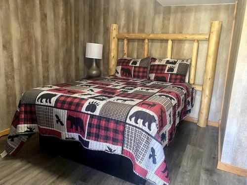a bed with a quilt and pillows on it at Cabin in Gatlingburg L in Gatlinburg