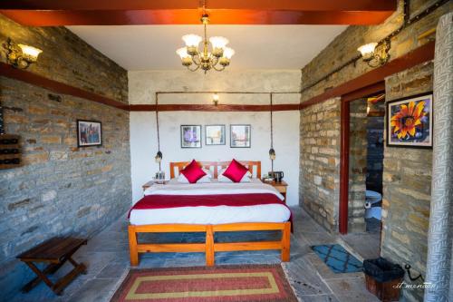 a bedroom with a bed in a brick wall at Itmenaan Estate in the Himalayas in Almora
