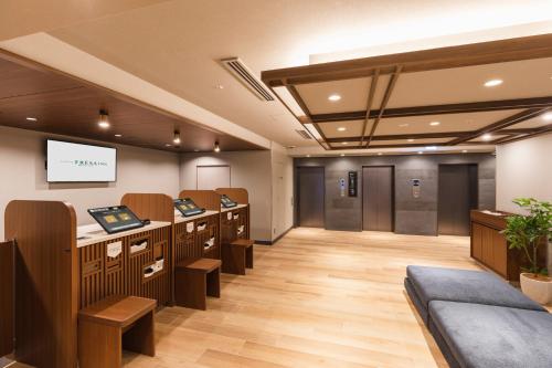 a salon with a waiting room with chairs and a screen at Sotetsu Fresa Inn Kyoto-Kiyomizu Gojo in Kyoto