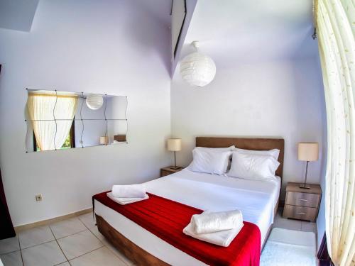 ein Schlafzimmer mit einem weißen Bett mit zwei Handtüchern darauf in der Unterkunft Sani Villa Lili 7 in Sani Beach