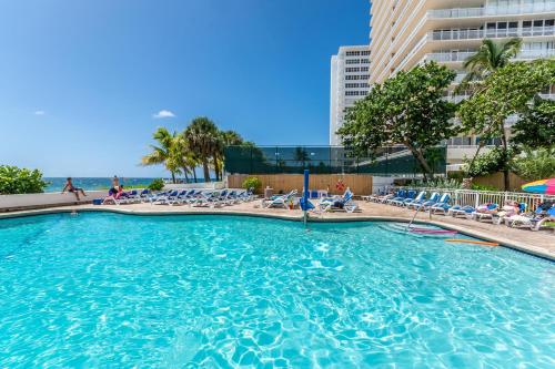 a large swimming pool with chairs and the ocean at Ocean Beach Condo 3BR On the Sand 505 in Fort Lauderdale