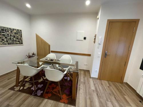 a dining room with a glass table and white chairs at Sweet Dreams in Campdevánol