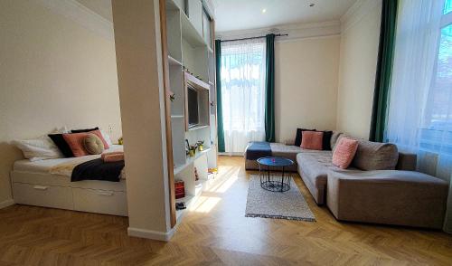 salon z łóżkiem i kanapą w obiekcie SMARAGD Apartman w Győr