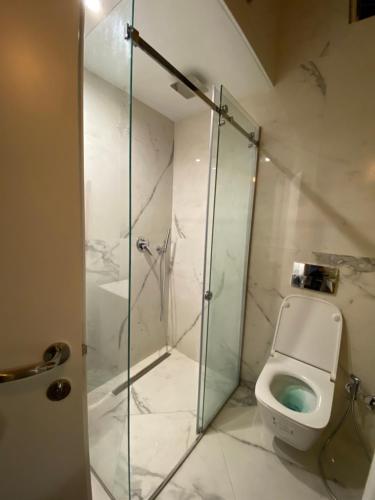 La salle de bains est pourvue d'une douche en verre et de toilettes. dans l'établissement Lovely Loft 1-Bedroom in the heart of Tirana, à Tirana