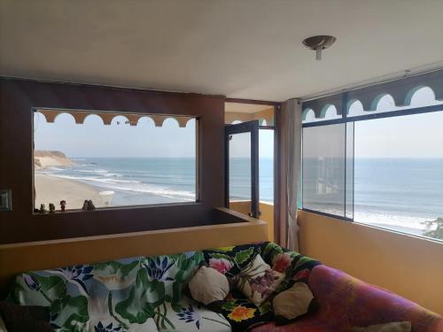 a living room with a view of the beach and a couch at Hospedaje Restaurante El Hombre in Puerto Chicama