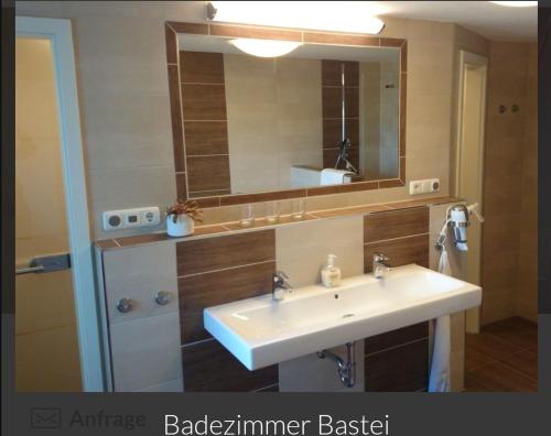 La salle de bains est pourvue d'un lavabo et d'un miroir. dans l'établissement Guesthouse Elbsandstein App. Bastei, à Rathmannsdorf