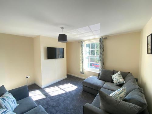 a living room with a couch and a tv at Hodge Bower Holidays, Ironbridge - Sedgwick in Ironbridge