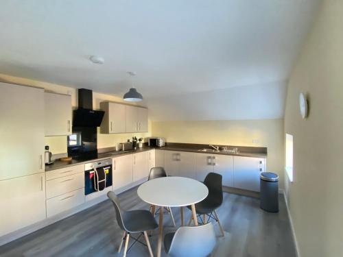 a kitchen with a table and chairs in a room at Hodge Bower Holidays, Ironbridge - Sedgwick in Ironbridge