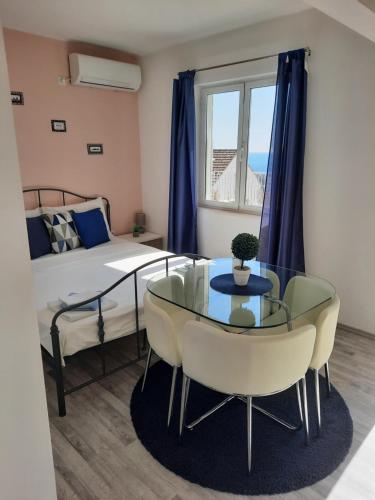 een kamer met een bed en een glazen tafel en stoelen bij Studio apartment S&N in Dubrovnik
