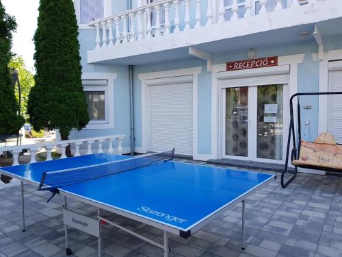 una mesa de ping pong azul frente a una casa en Crystal és Susanne Panzió, en Siófok