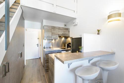 une cuisine avec un comptoir et deux tabourets dans l'établissement 