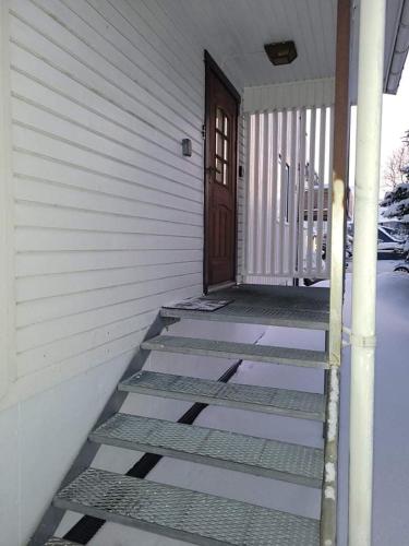 a porch of a house with a door and stairs at FeelHome One bedroom apartment Vidarsveg in Tromsø