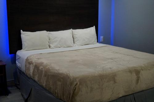 
a bed with a white bedspread and pillows at Celebration Suites in Orlando
