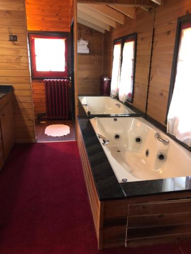 a large bathroom with a tub in a cabin at La Miralejos in San Carlos de Bariloche