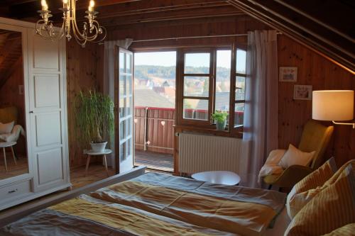 a bedroom with a bed and a large window at Ferienwohnung Vogelnest in Dietingen