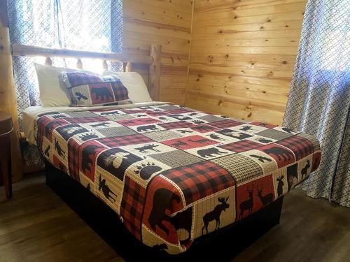 a bedroom with a bed with a quilt on it at Big Bear River House, Outdoor Grill, River Access, 3 Beds in Pigeon Forge