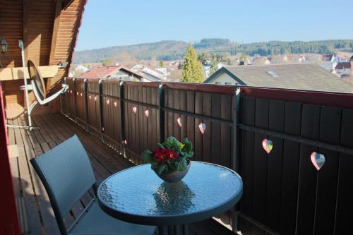 a table on a balcony with a view of a town at Ferienwohnung Vogelnest in Dietingen
