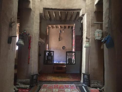 a hallway of a building with a room with a table at Kasbah Maktob Tamnougalt in Agdz