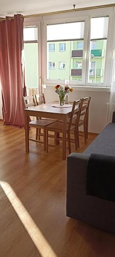 uma mesa de jantar com cadeiras e um vaso de flores em Apartamenty Gryfice Centrum - Nadrzeczna 2 em Gryfice