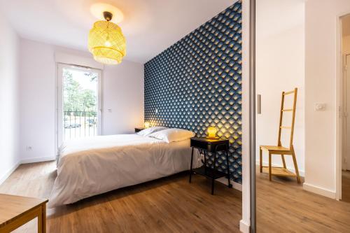 une chambre avec un lit et un mur bleu dans l'établissement Magnifique villa 4 pers à 10 min de la plage à pied, à Seignosse