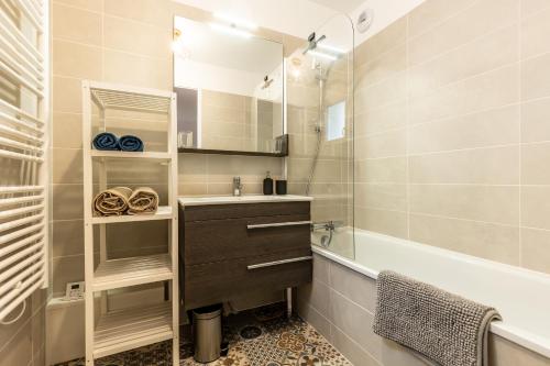 une salle de bain avec un lavabo, une baignoire et un miroir dans l'établissement Magnifique villa 4 pers à 10 min de la plage à pied, à Seignosse