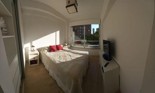 Habitación pequeña con cama y ventana en DEPTO NUEVO CON PILETA EN NUÑEZ en Buenos Aires