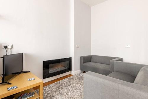 a living room with a couch and a fireplace at The Hideaway, Family apartment close to the beach. in Paignton