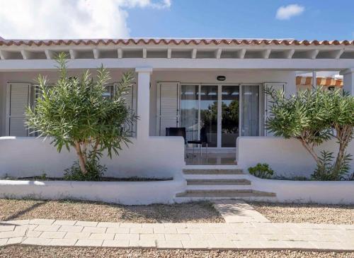 a white house with two trees in front of it at Roquetes Bungalows Premium - Formentera Break in Es Pujols