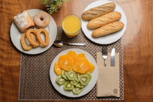 een tafel met schalen brood, sinaasappels en croissants bij Hospedium Hotel Casino Del Tormes in Salamanca