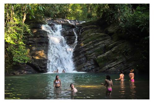 people in the water in front of a waterfall at Las Brisas del Sur in Ojochal