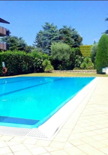 basen z błękitną wodą na dziedzińcu w obiekcie Welcome Traveller L'APPARTAMENTO DI NORMA w mieście Bardolino
