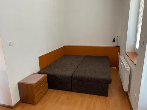 1 dormitorio pequeño con 1 cama y suelo de madera en Karlovický dvůr 251 en Karlovice
