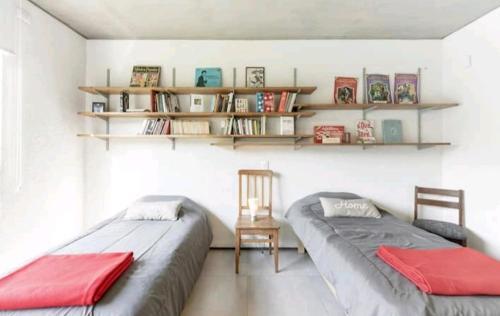 2 Betten in einem Zimmer mit Regalen an der Wand in der Unterkunft House in Chacras de Coria Ruta del Vino in Chacras de Coria