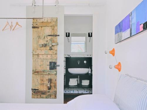 チェーリエ・メッサーピカにあるTrullo Santangeloのベッド1台と木製のドアが備わる客室です。