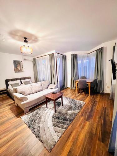 a living room with a couch and a table at Pirin Golf Hotel Private Studios - Sani, Bansko in Razlog